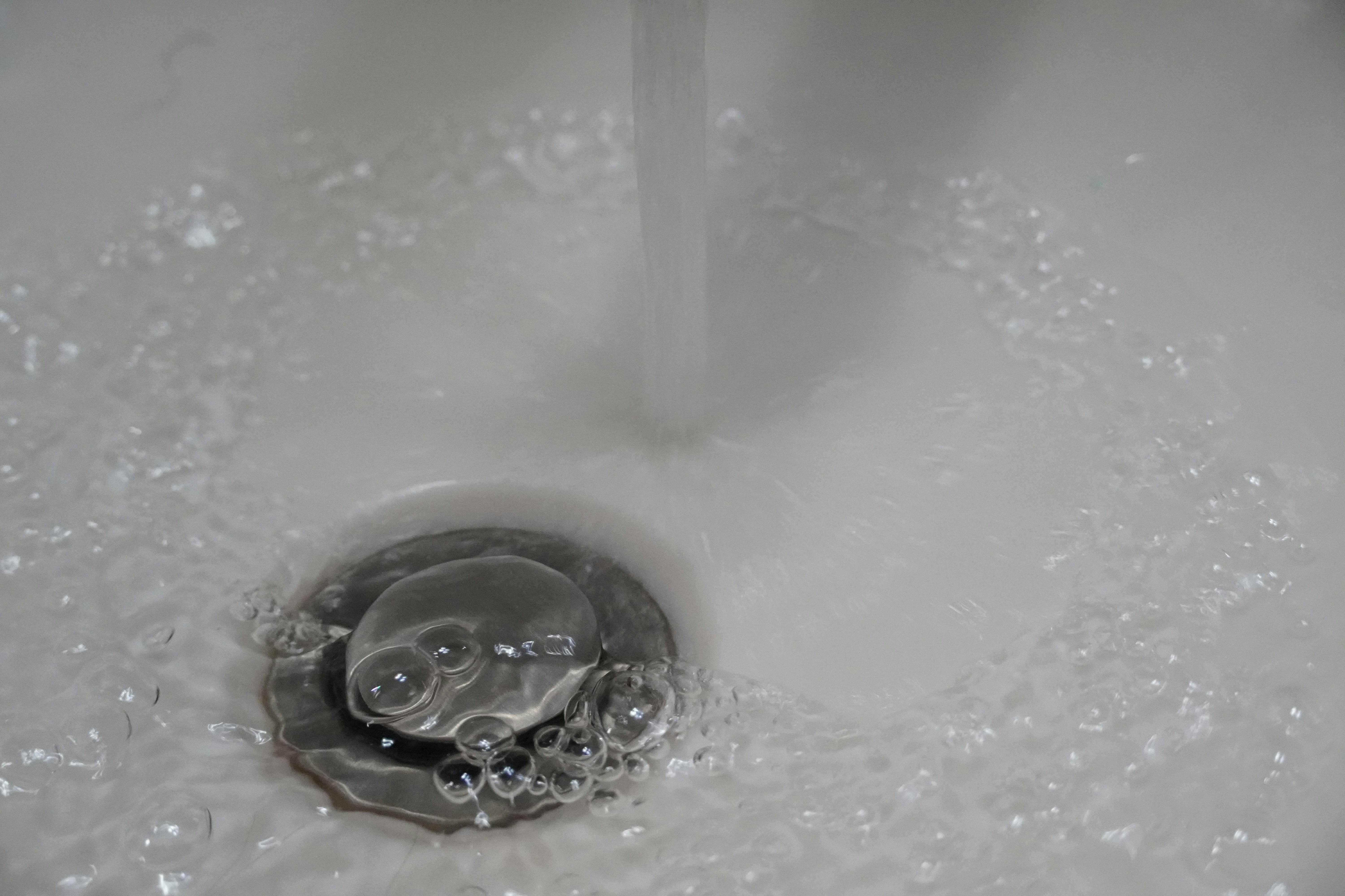 a close up of a sink with water running down it